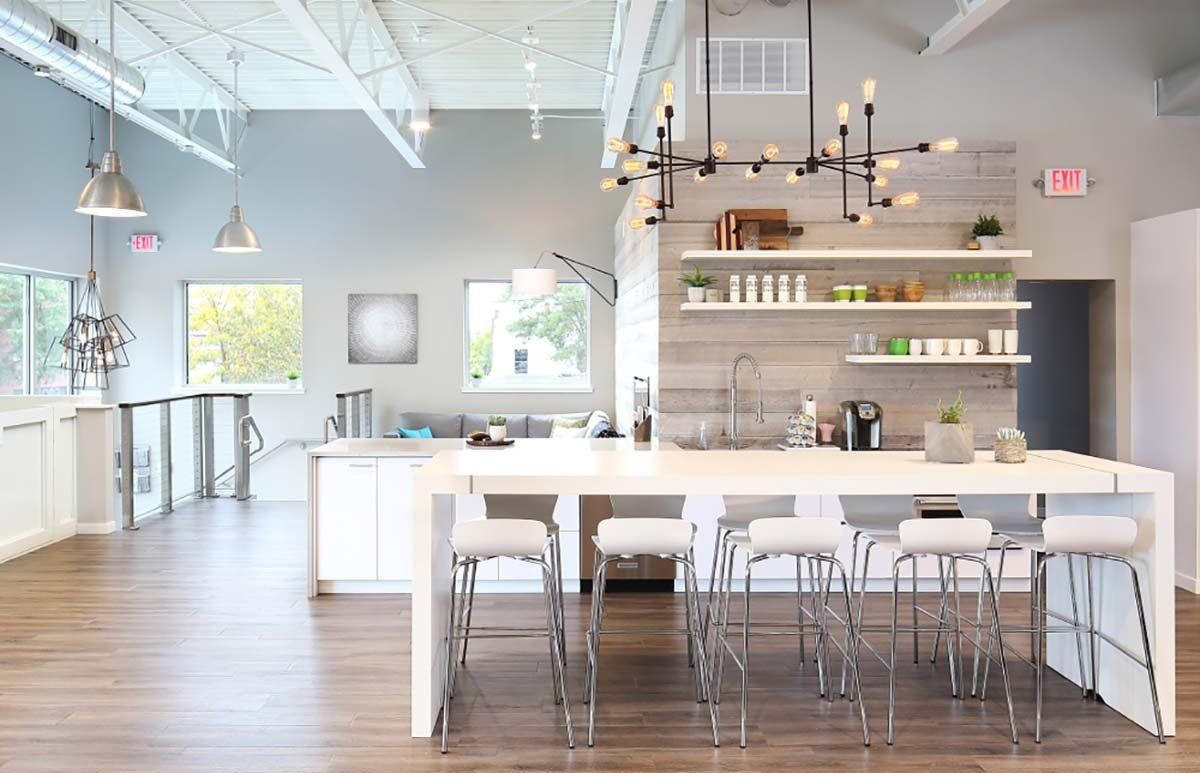 A large kitchen with a long table and stools.