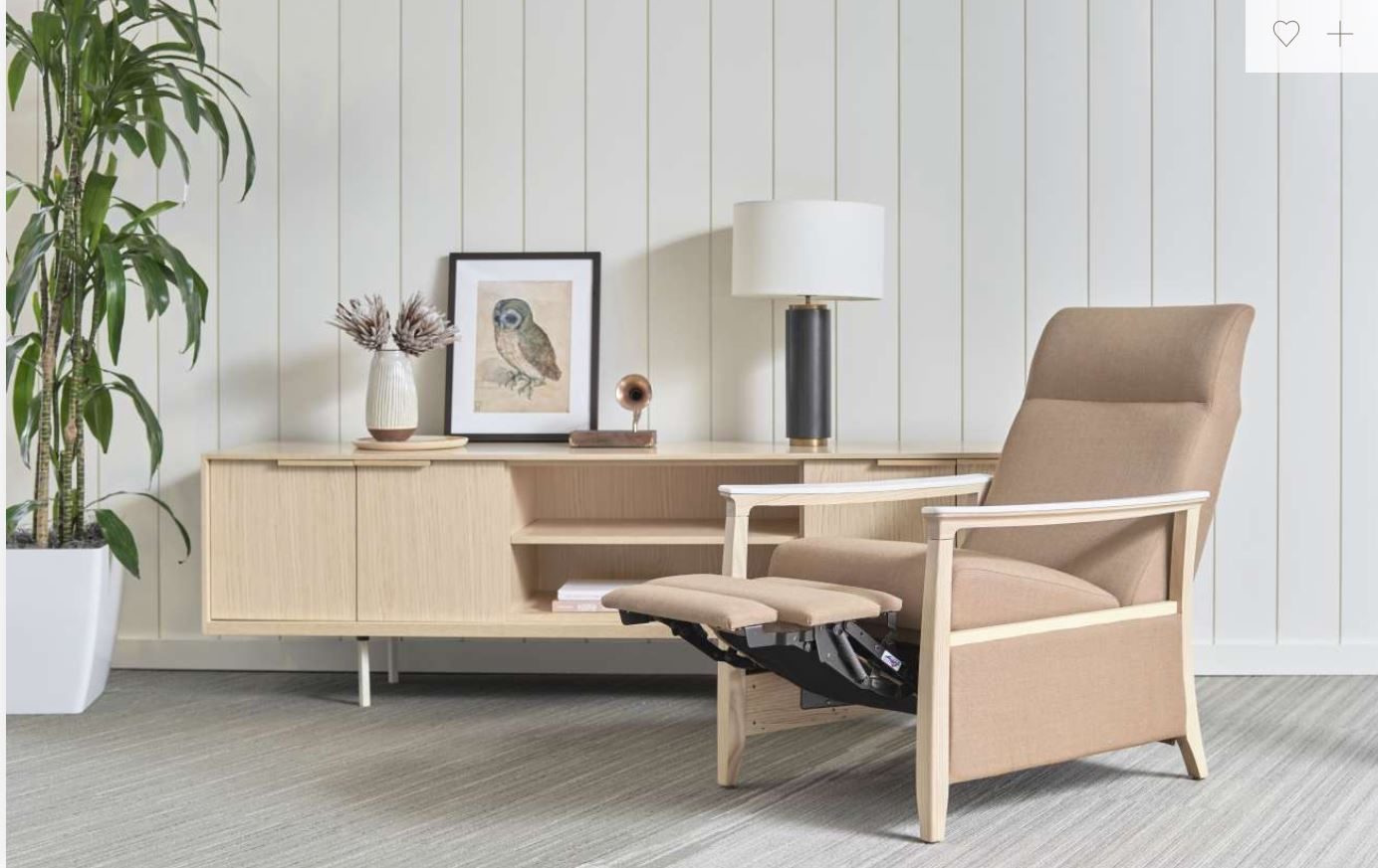 A recliner chair is sitting in a living room next to a plant.