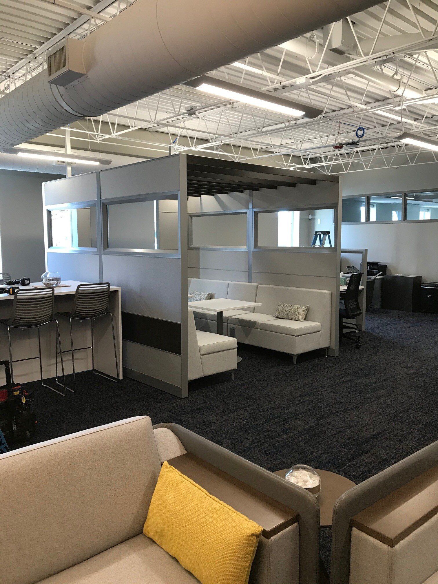 A living room with a couch , chairs , tables and dividers.