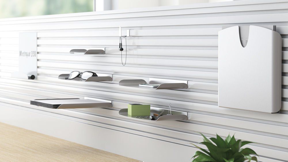 A white wall with shelves and a plant on it.