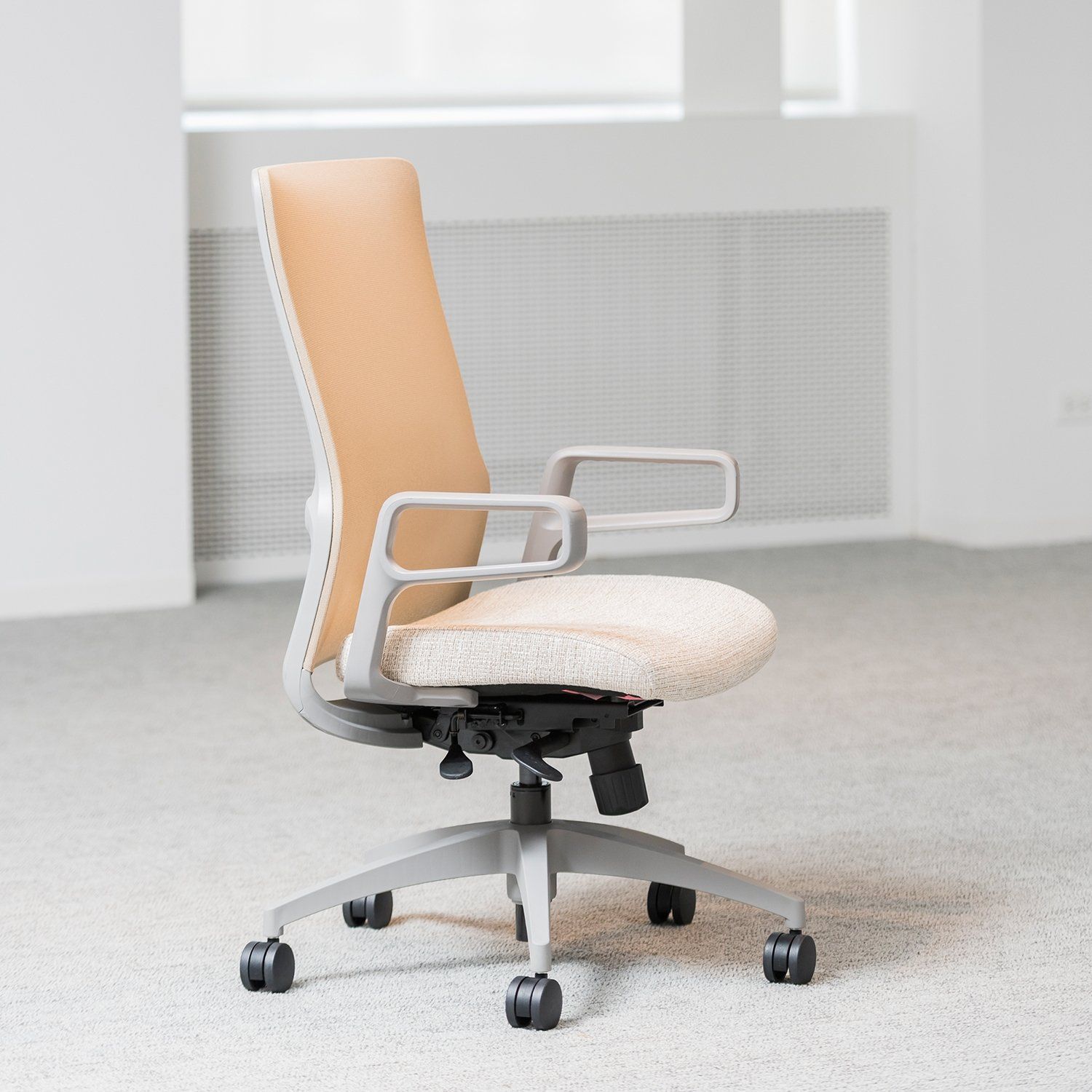 An office chair is sitting on the floor in an empty room.