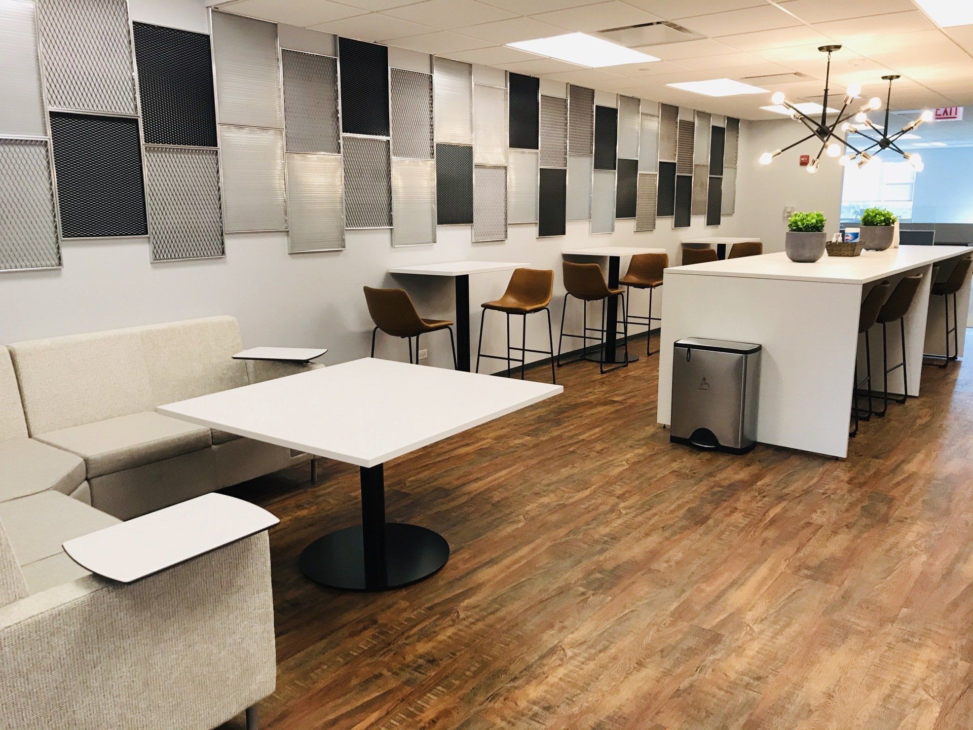 A living room with a couch , table , chairs and a trash can.