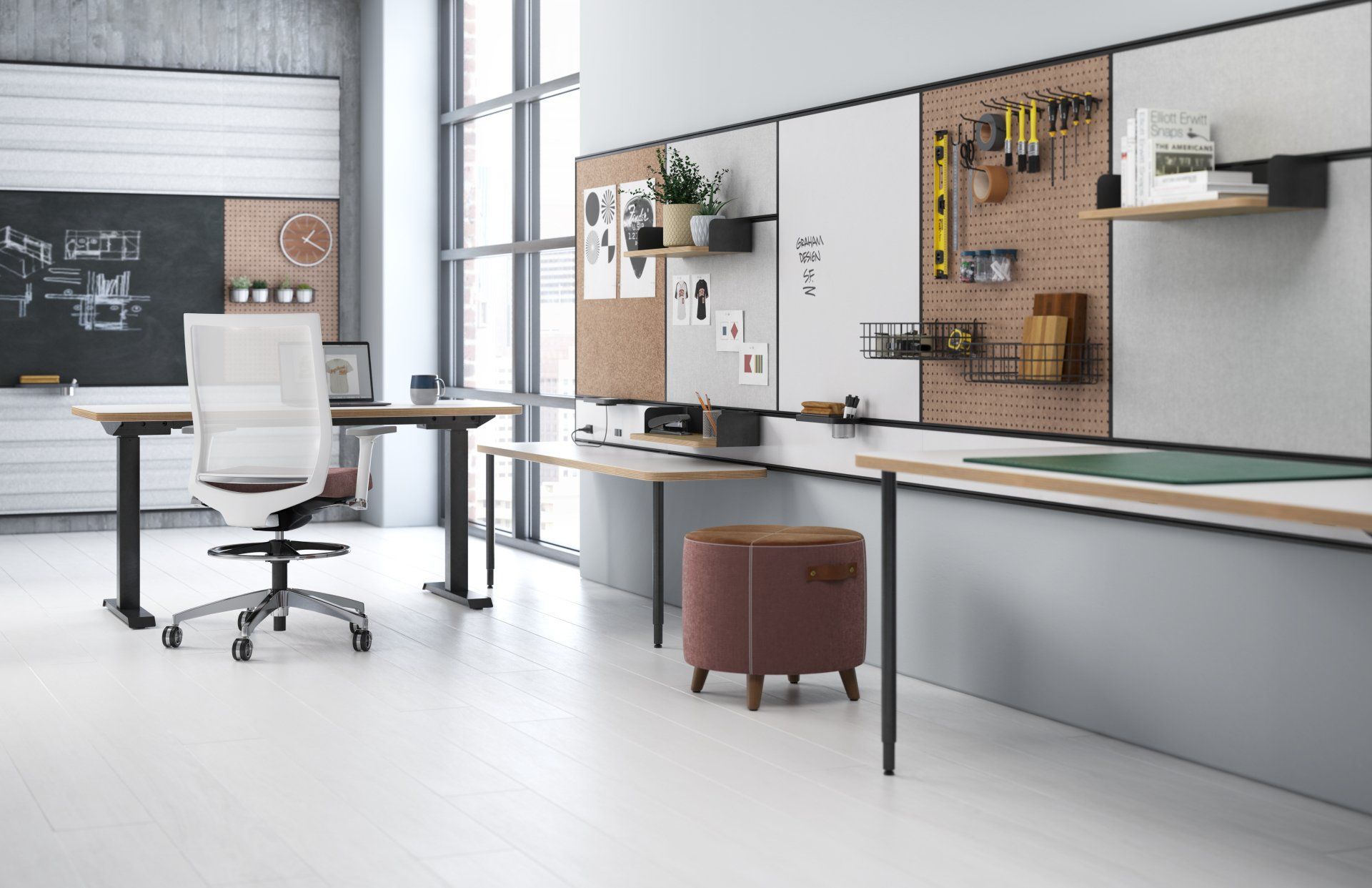 A room with a desk , chair , ottoman and a chalkboard.