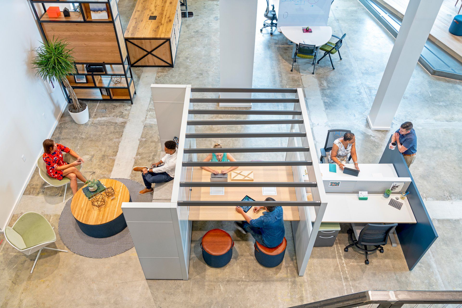 A group of people are sitting at desks in an office.