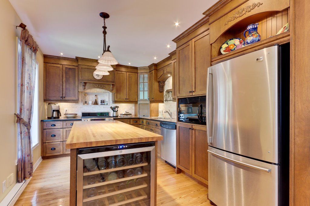 Une cuisine avec électroménagers en acier inoxydable et armoires en bois