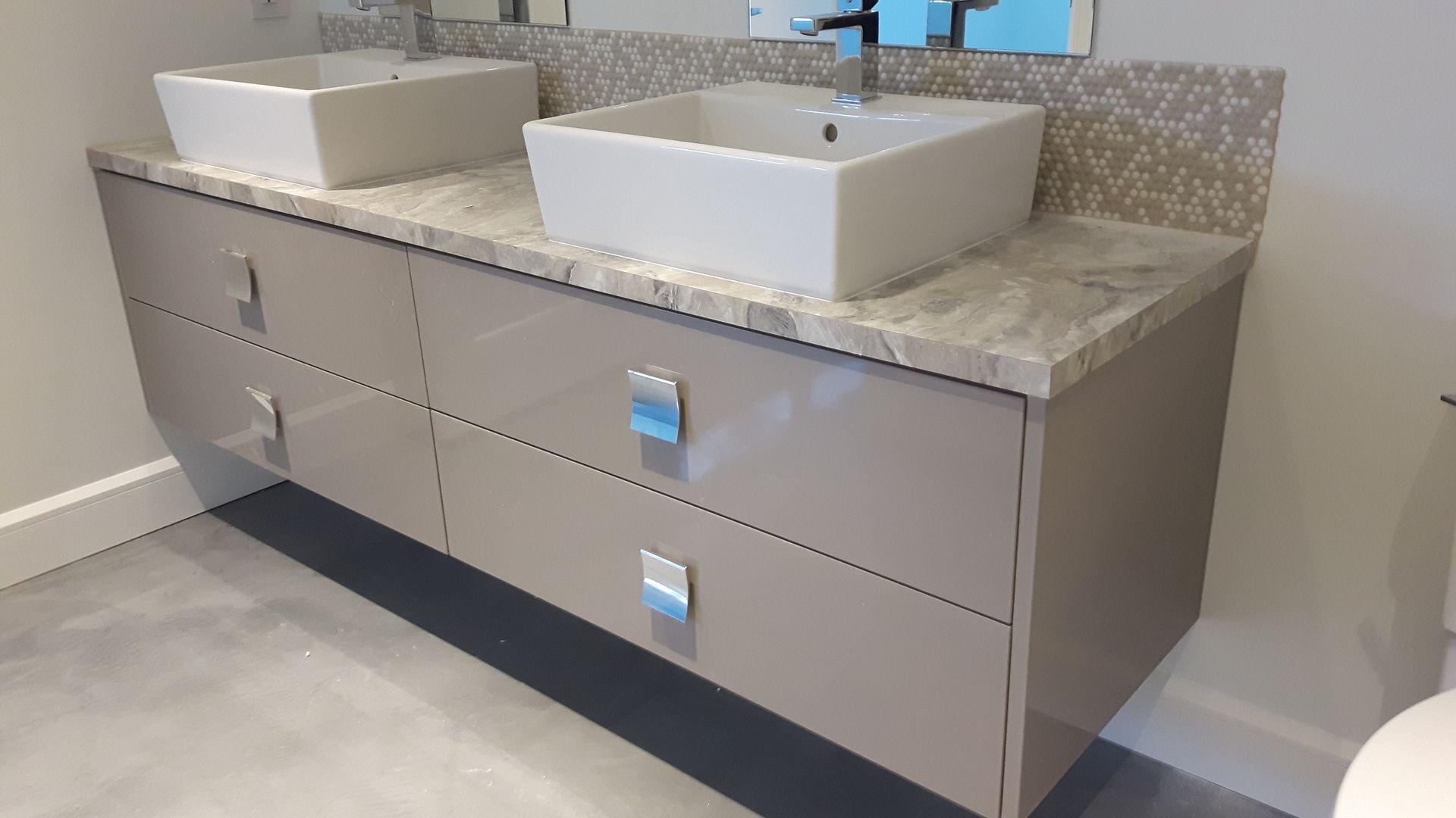 Une salle de bain avec deux vasques et un WC.