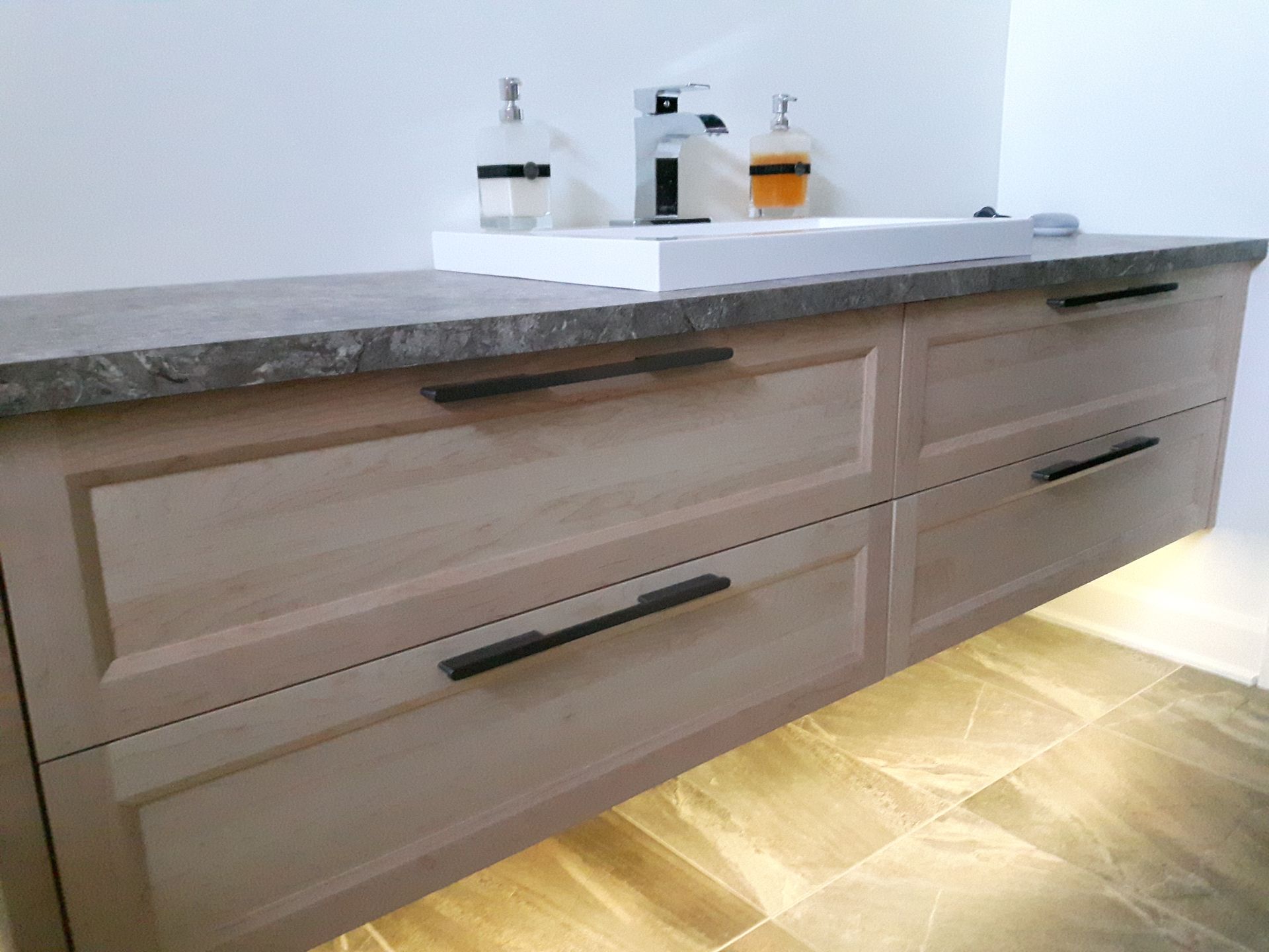 Un meuble de salle de bain avec tiroirs et lavabo.