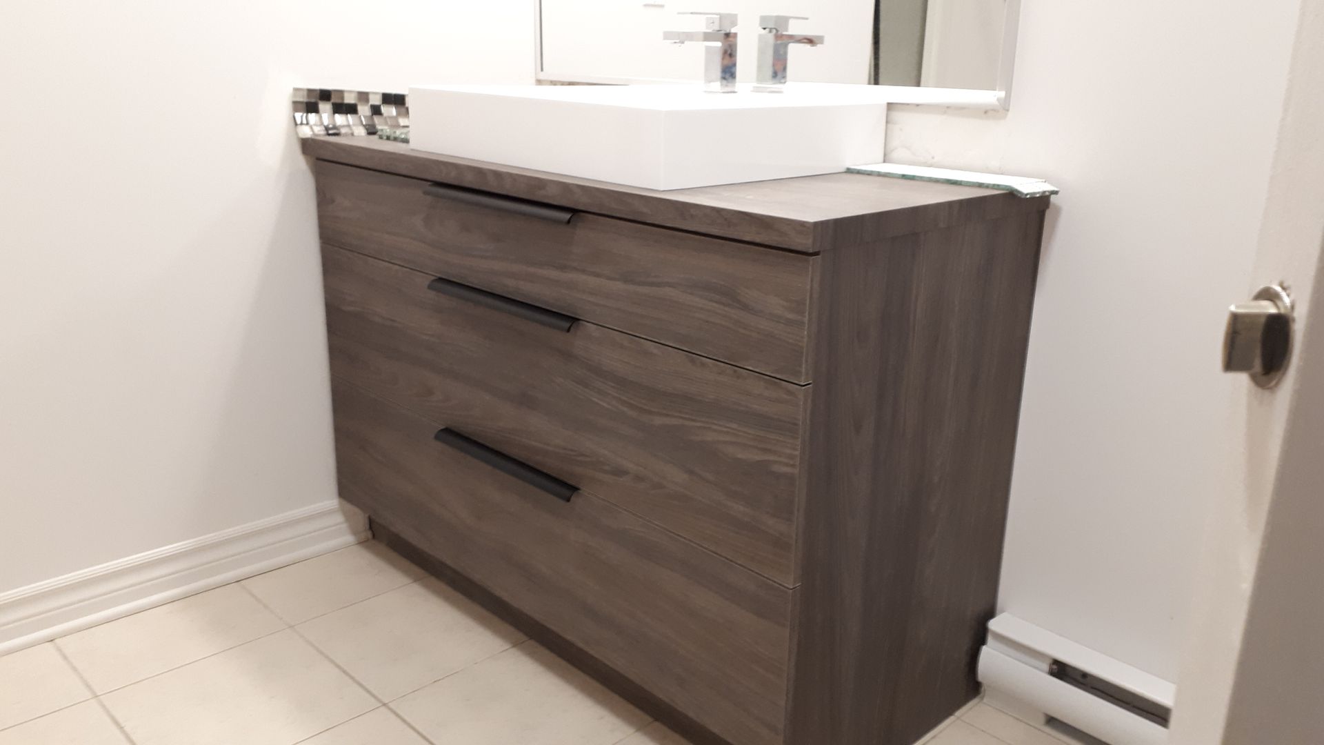 Une salle de bain avec une vasque en bois et un lavabo.