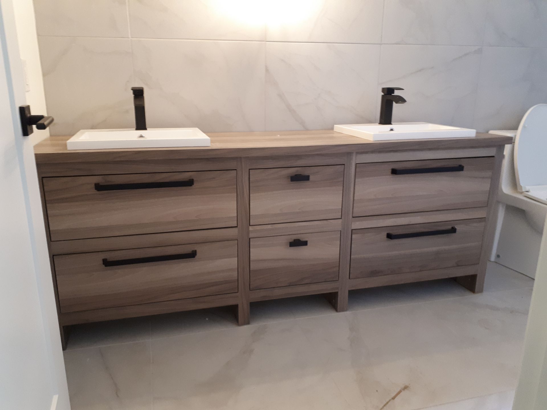 Une salle de bain avec deux vasques et un WC.