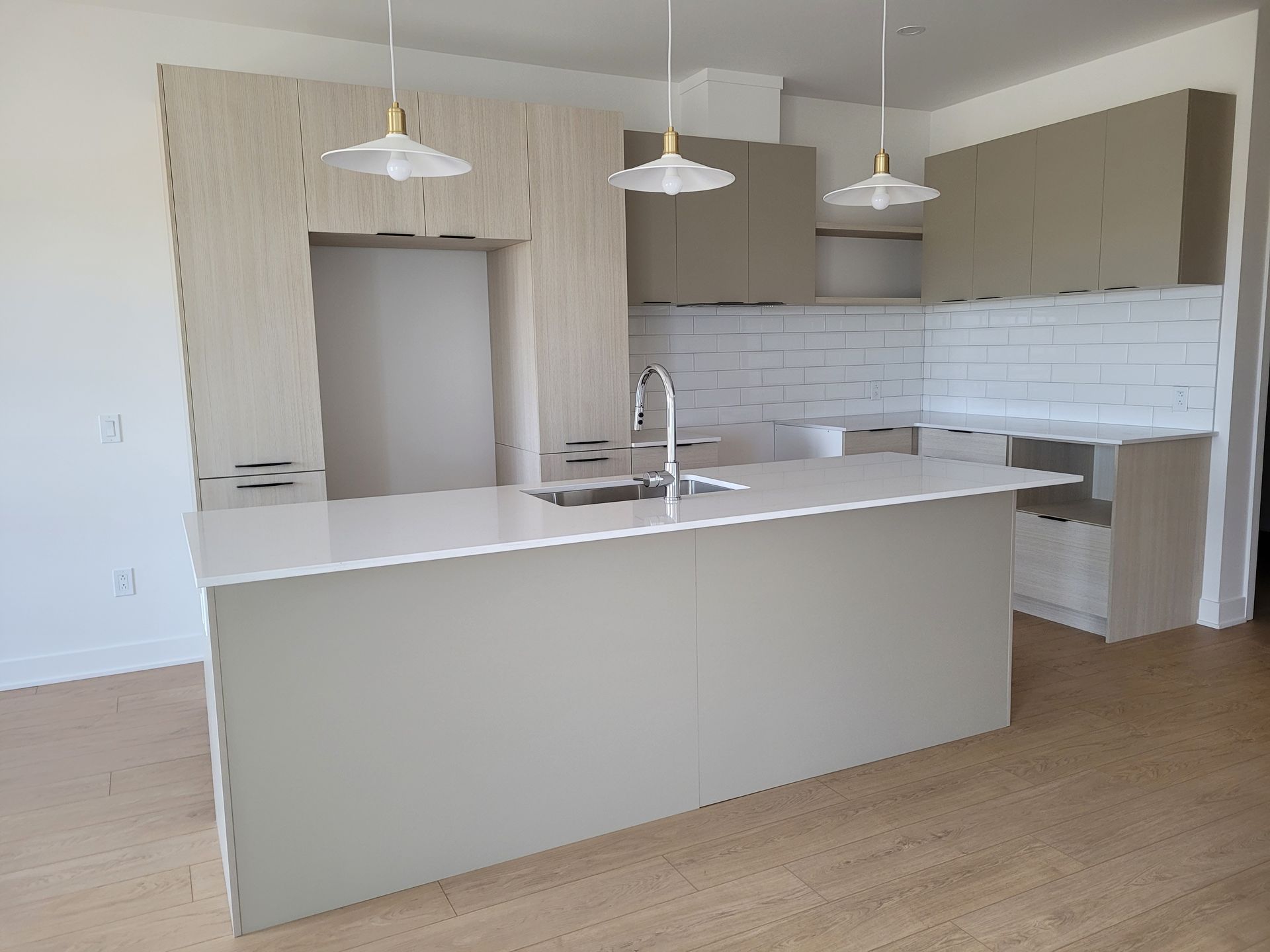 Une cuisine avec un grand îlot et un évier.