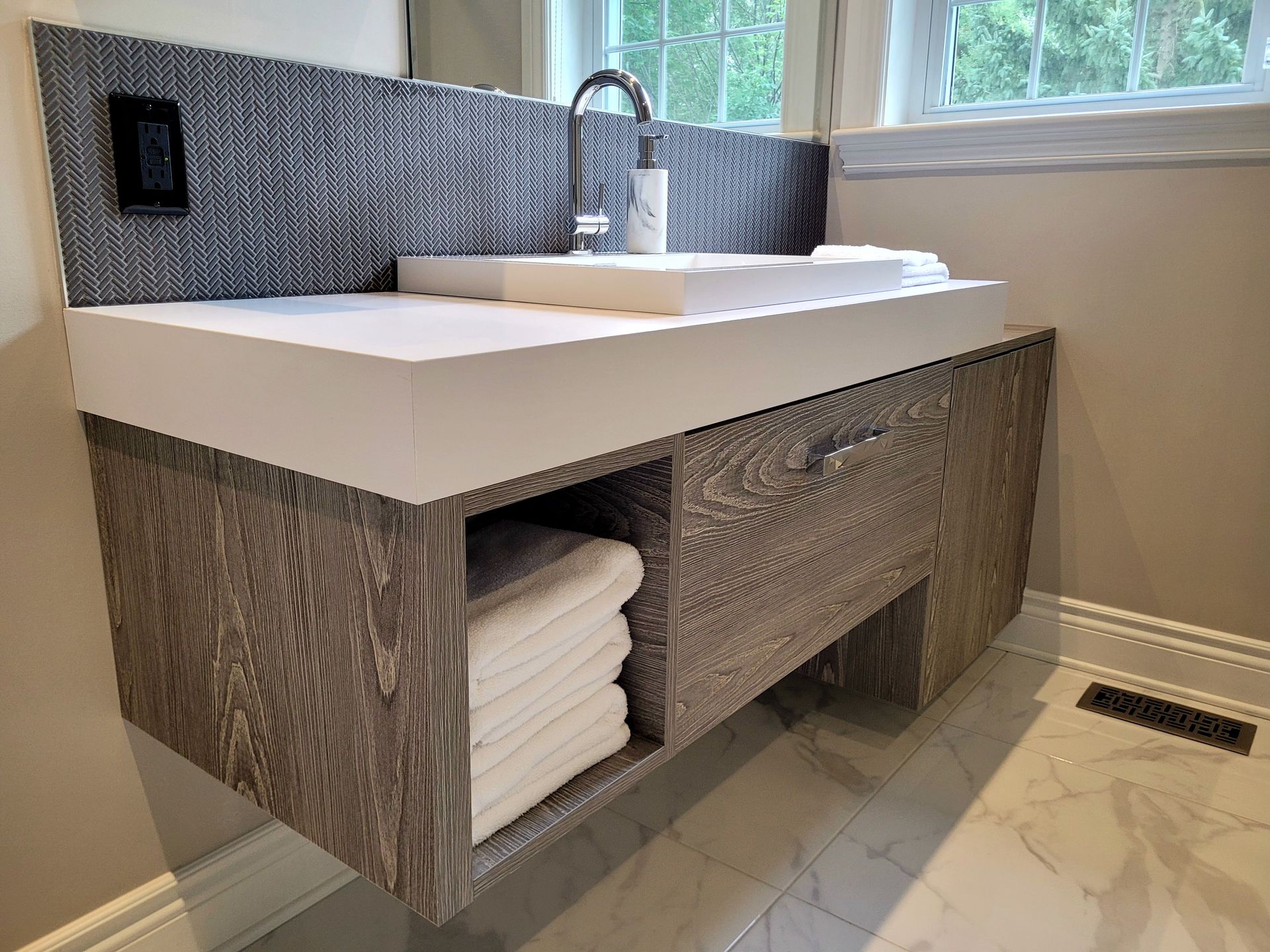 Un meuble de salle de bain avec un lavabo et un tiroir rempli de serviettes.