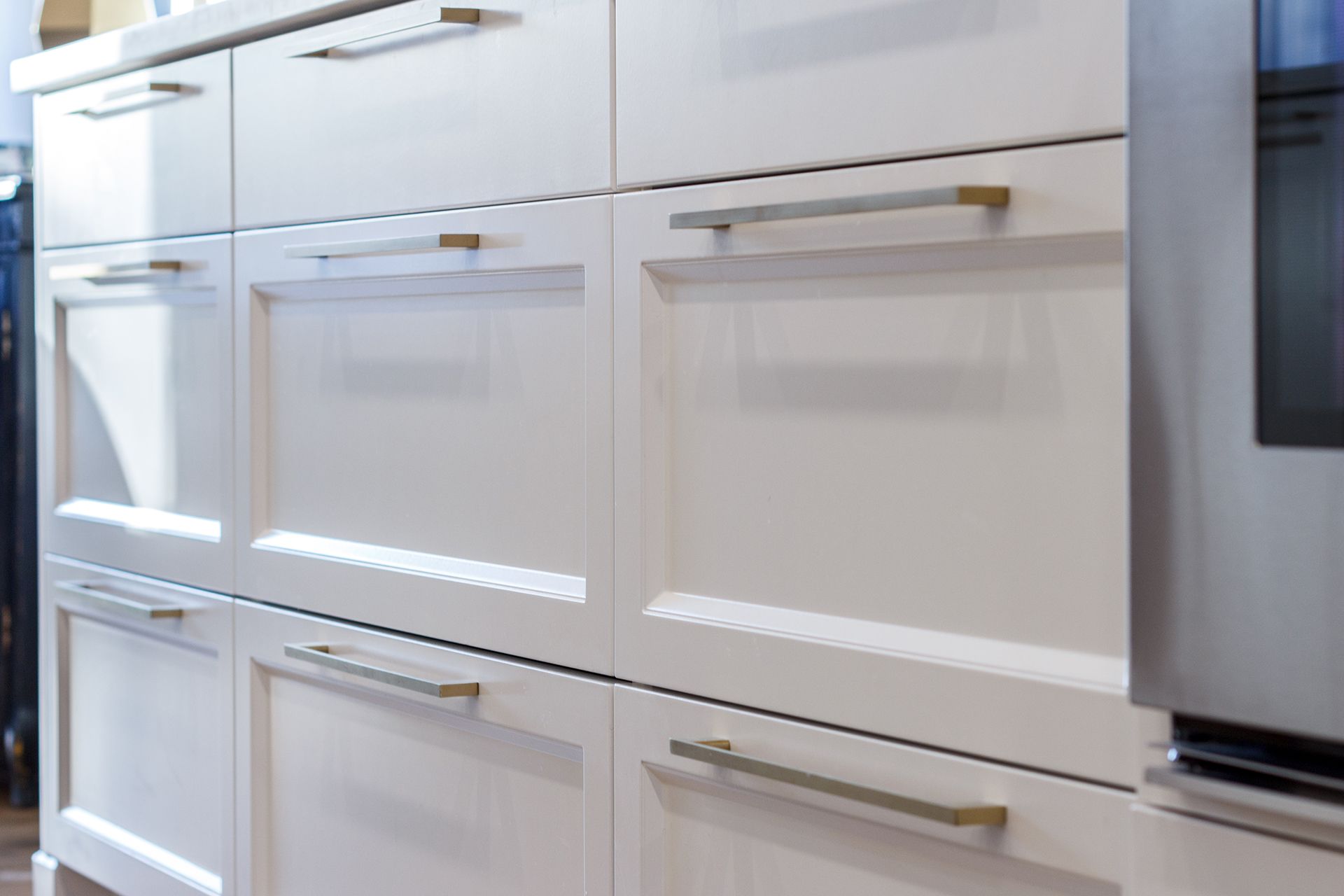 Armoires de cuisine blanches avec poignées argentées.