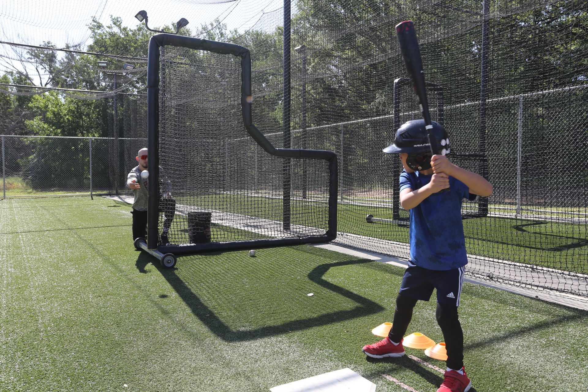 A coach is talking to two young boys on a soccer field.
