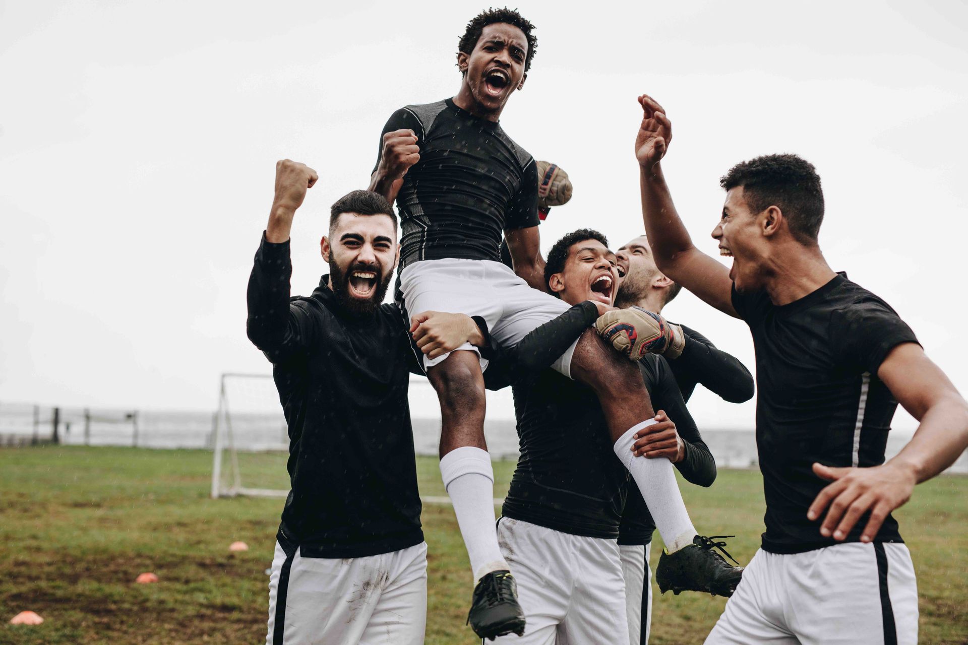 A group of soccer players are celebrating a victory on a field.