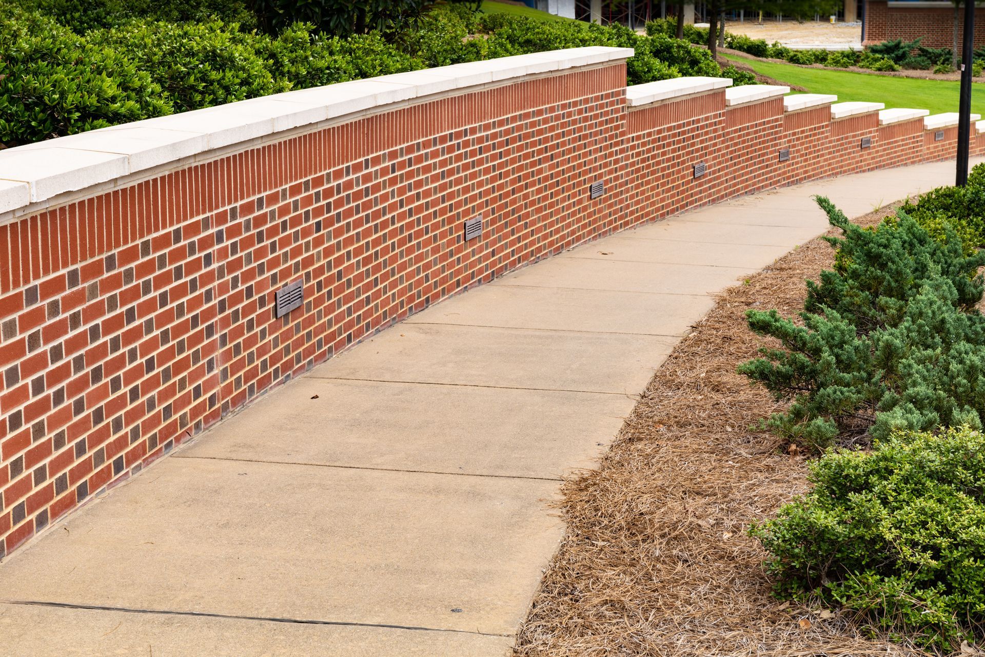 A brick wall along the side of a walkway