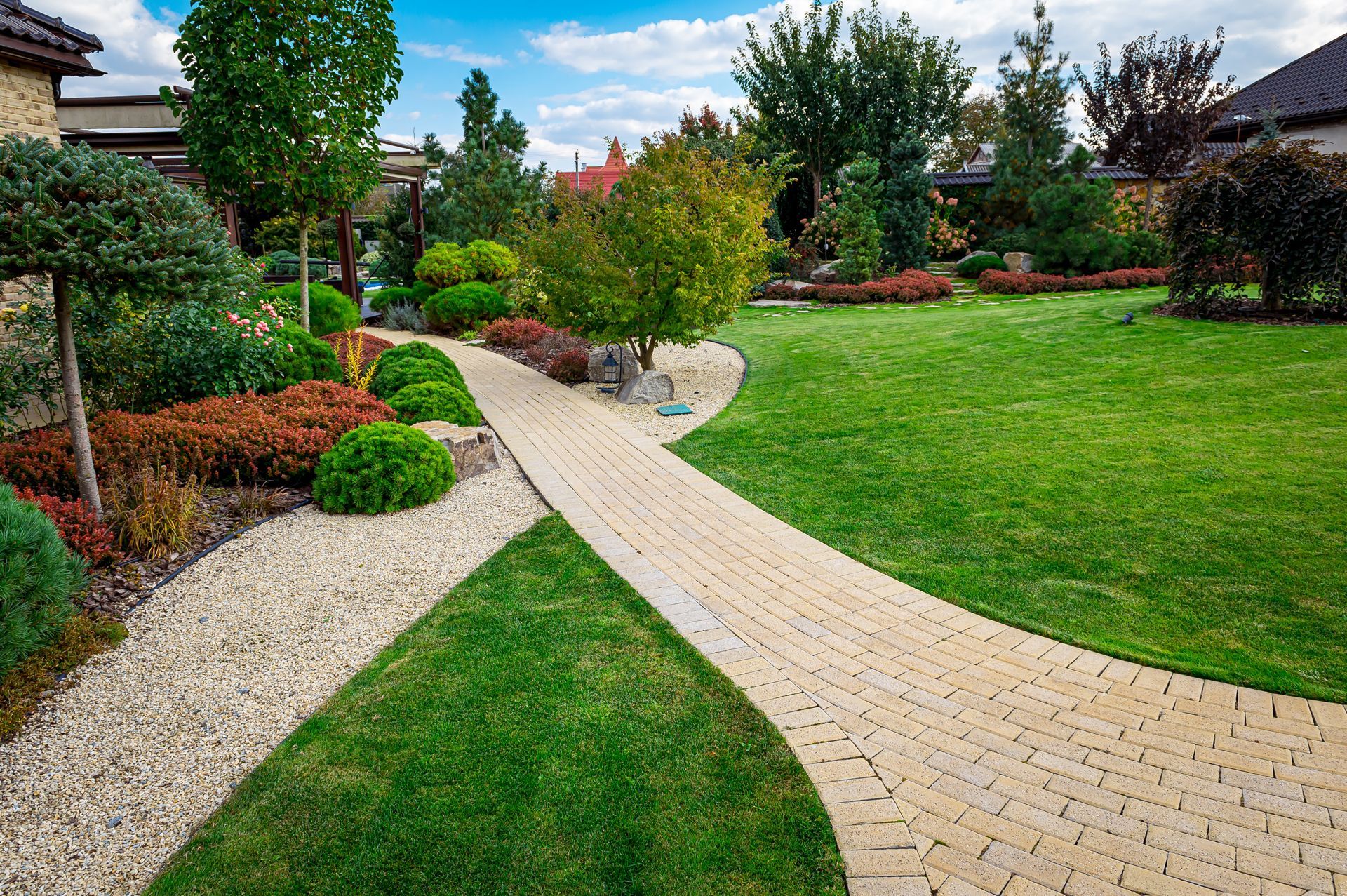A brick walkway leading through a lush green garden