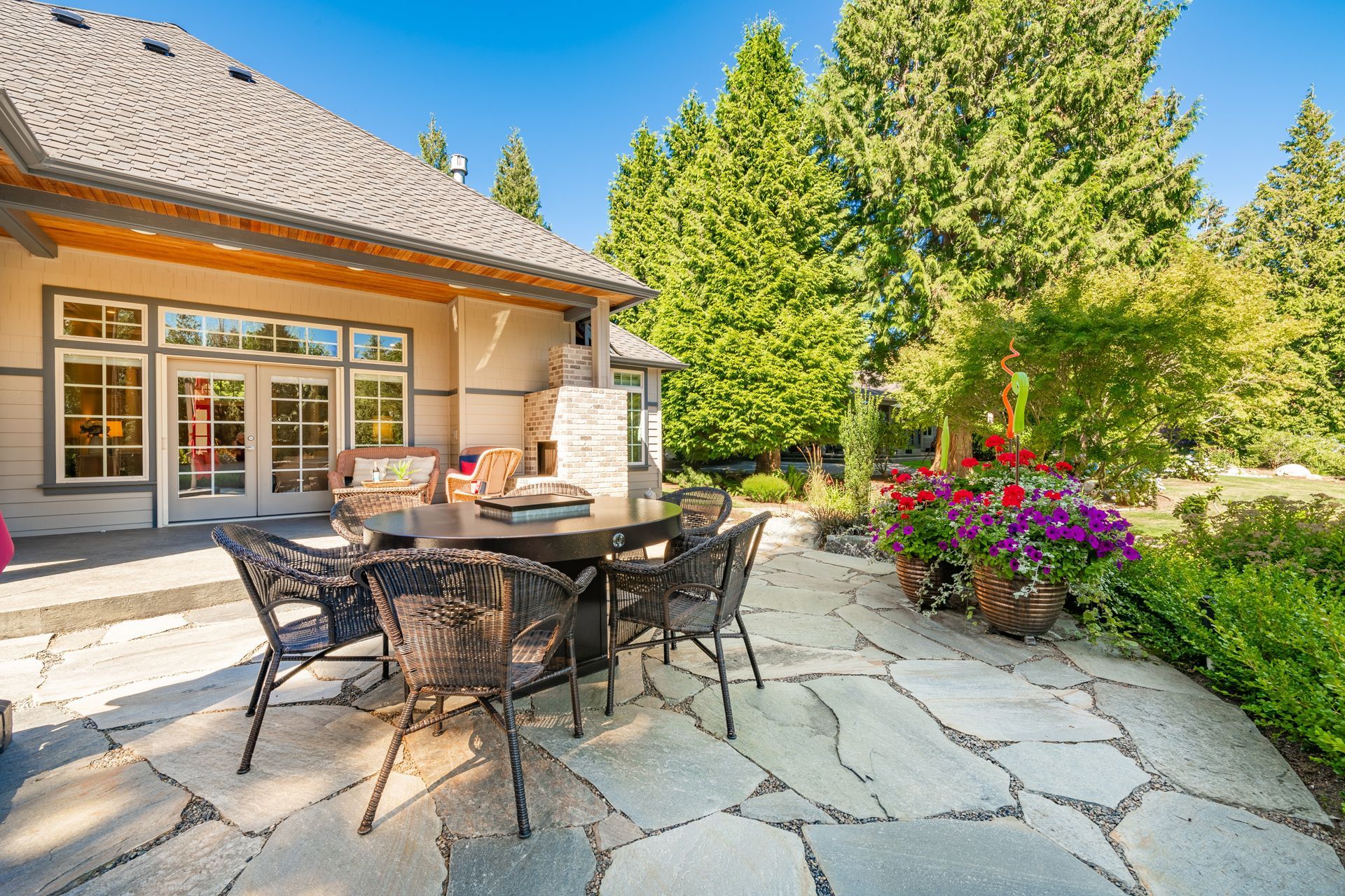 A patio with a table and chairs in front of a house