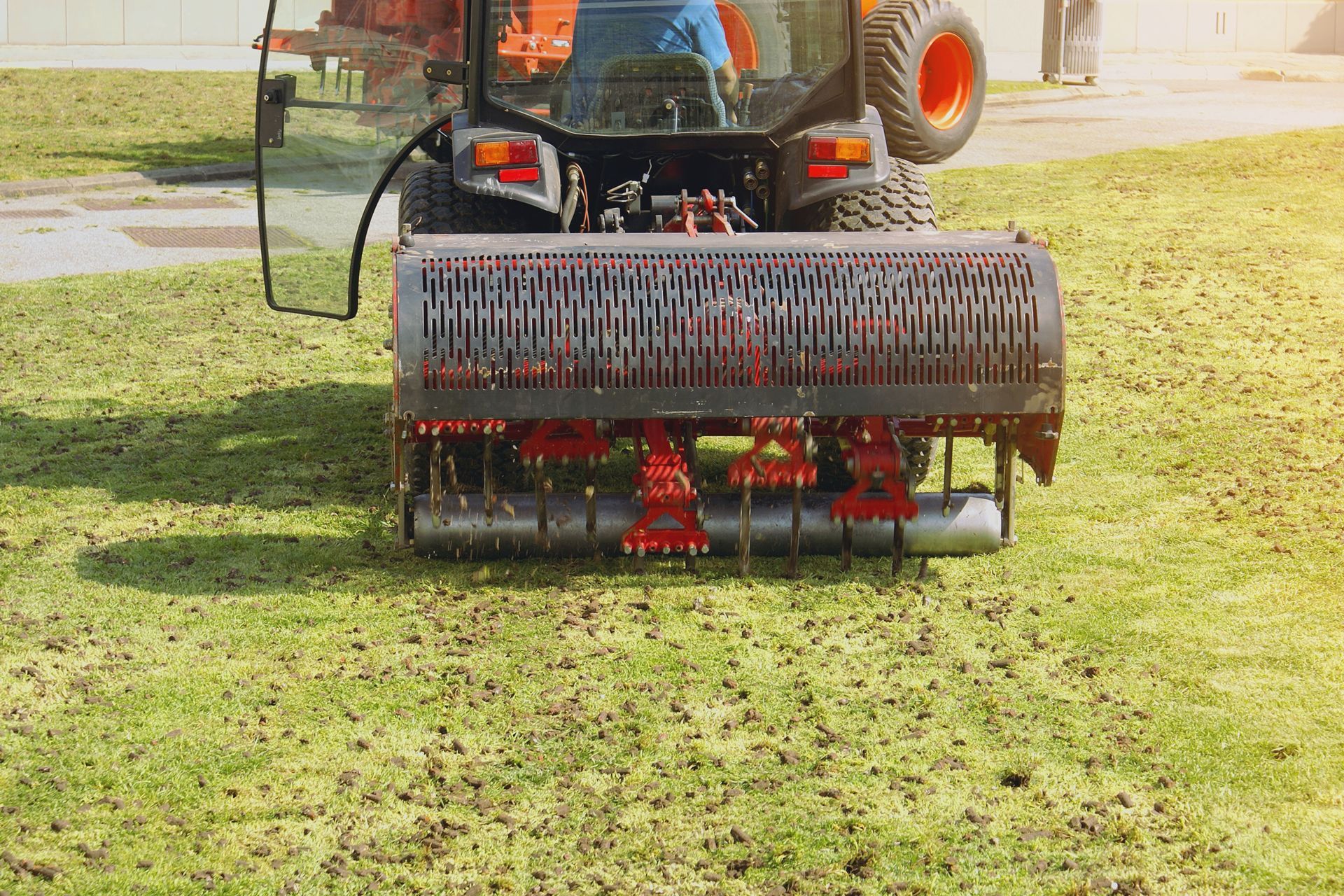 A tractor is spreading fertilizer on a lush green lawn