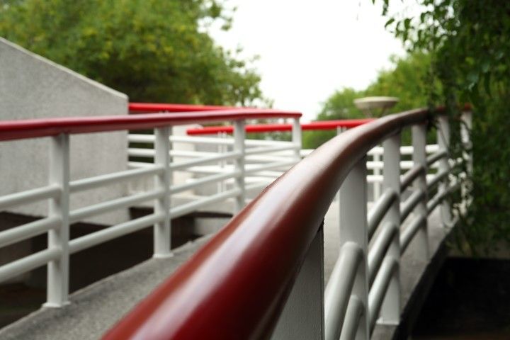 outdoor setting with red metal handrailings and trees