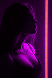A person in profile is illuminated by a vibrant vertical neon pink light strip against a dark background.