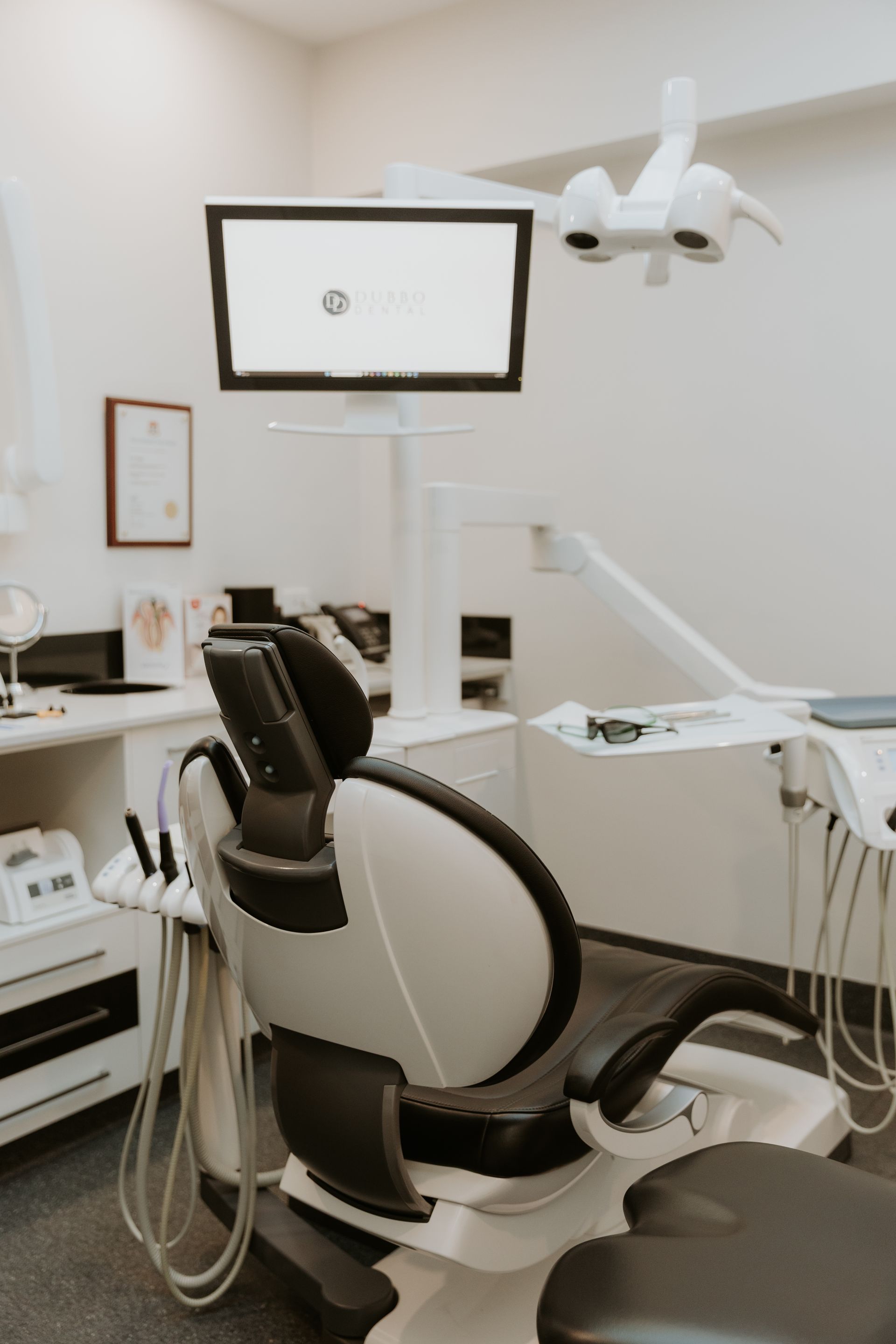 Dental Chair in a Clean, White Room, With a Monitor, Light, and Medical Instruments — Dubbo Dental in Dubbo, NSW