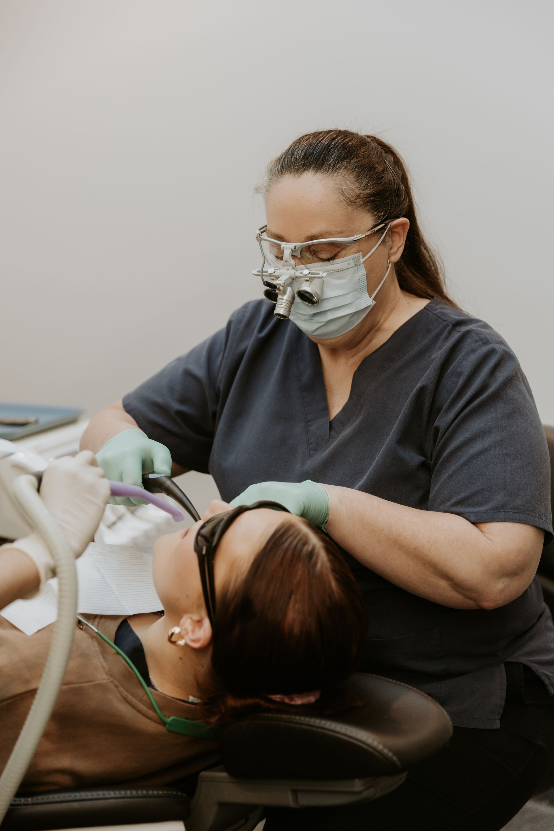 Dentist Wearing Mask and Glasses Examining Patient's Teeth in a Dental Office — Dubbo Dental in Dubbo, NSW