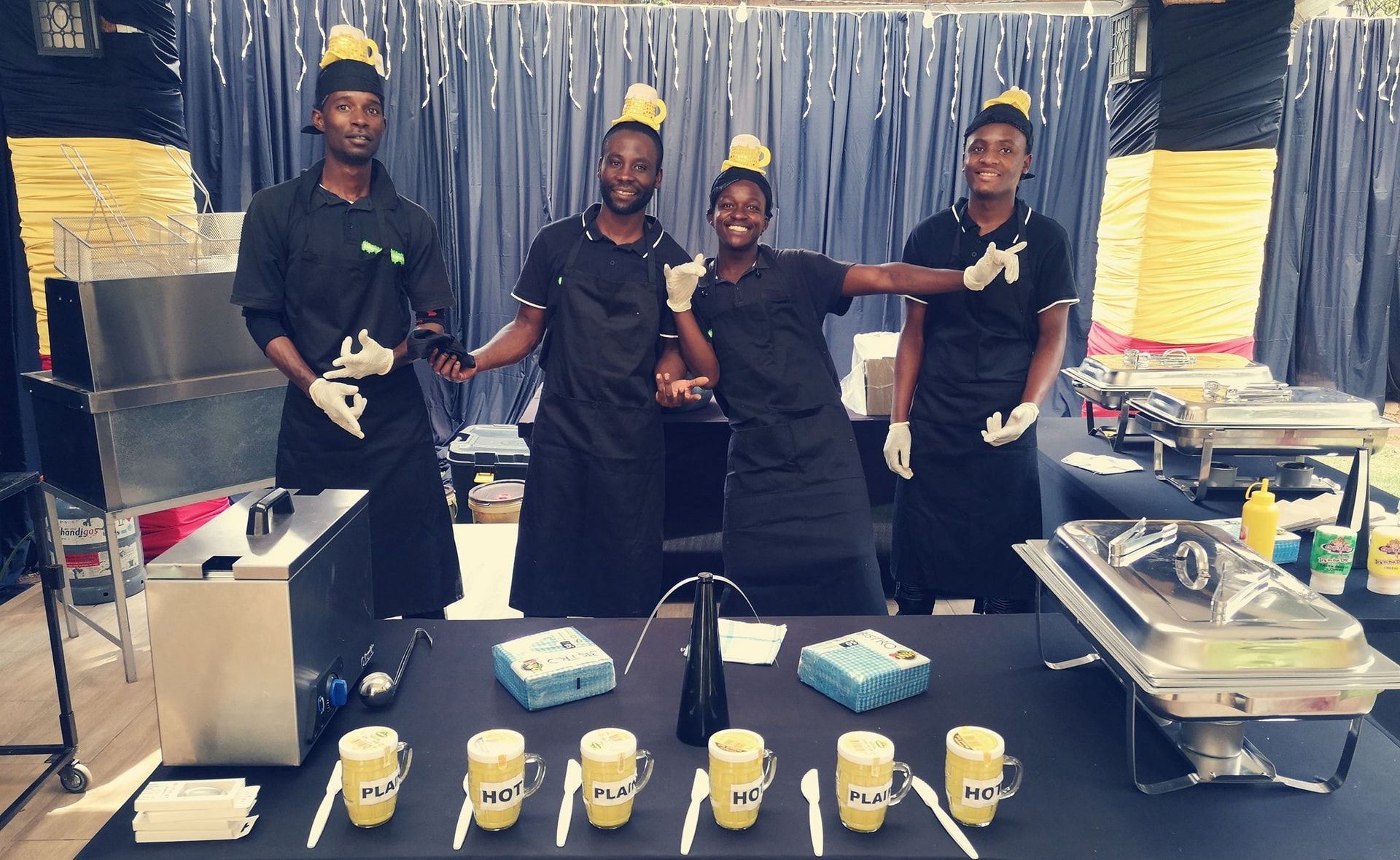 A group of people standing around a table with cups and spoons on it