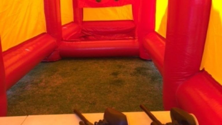 A red and yellow inflatable castle with two walkie talkies on the floor.