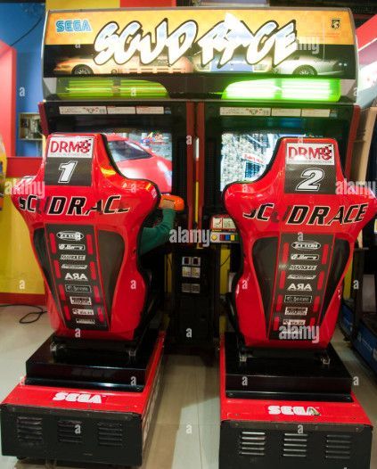Two red seats in front of a machine that says scud race