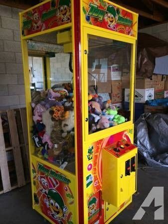 A yellow and red claw machine filled with stuffed animals.