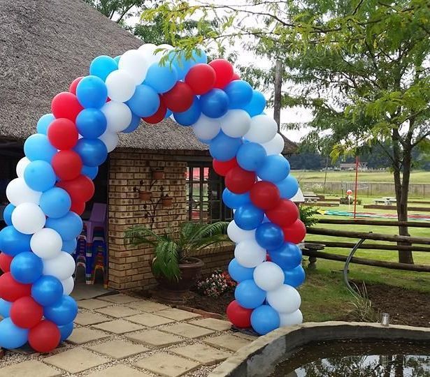 A large arch made of red white and blue balloons