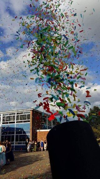 A bunch of confetti is flying in the air in front of a building.