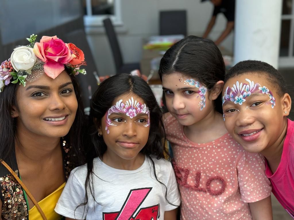A group of young girls with face paint on their faces are posing for a picture.