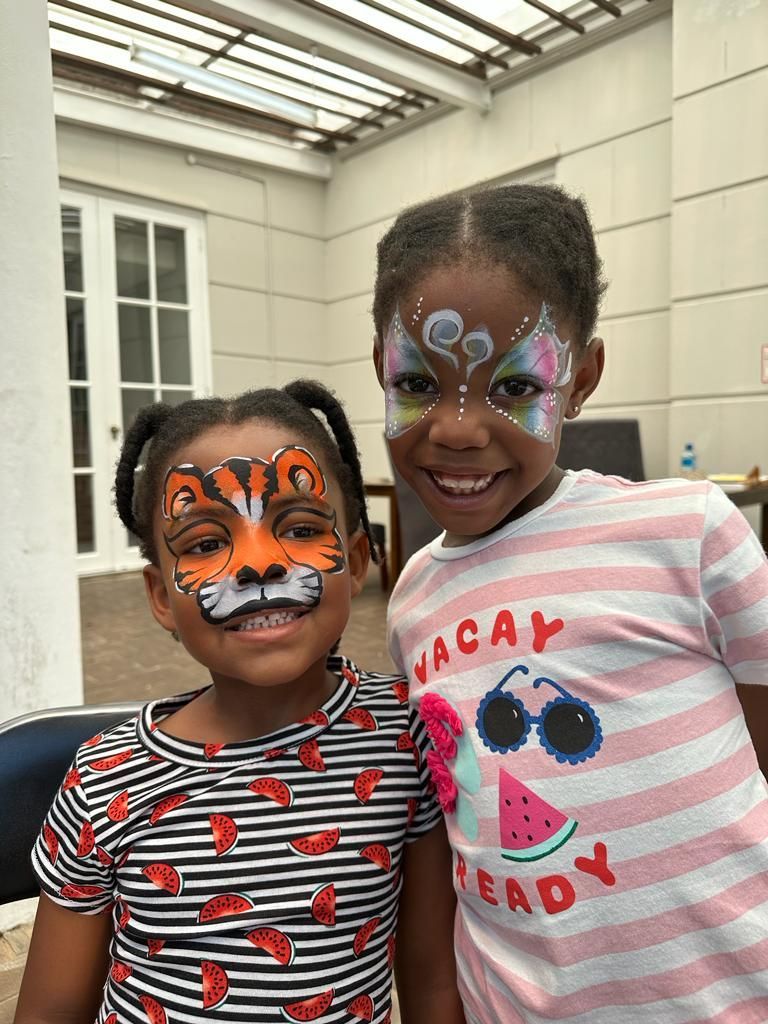 Two young girls with face paint on their faces.