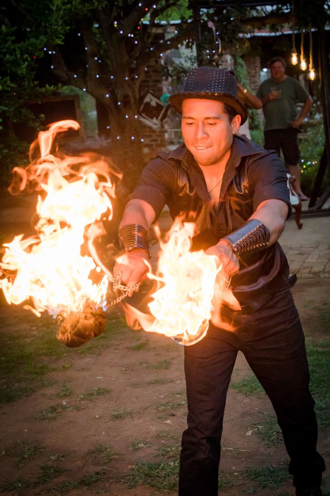 A man in a hat is holding a torch of fire.