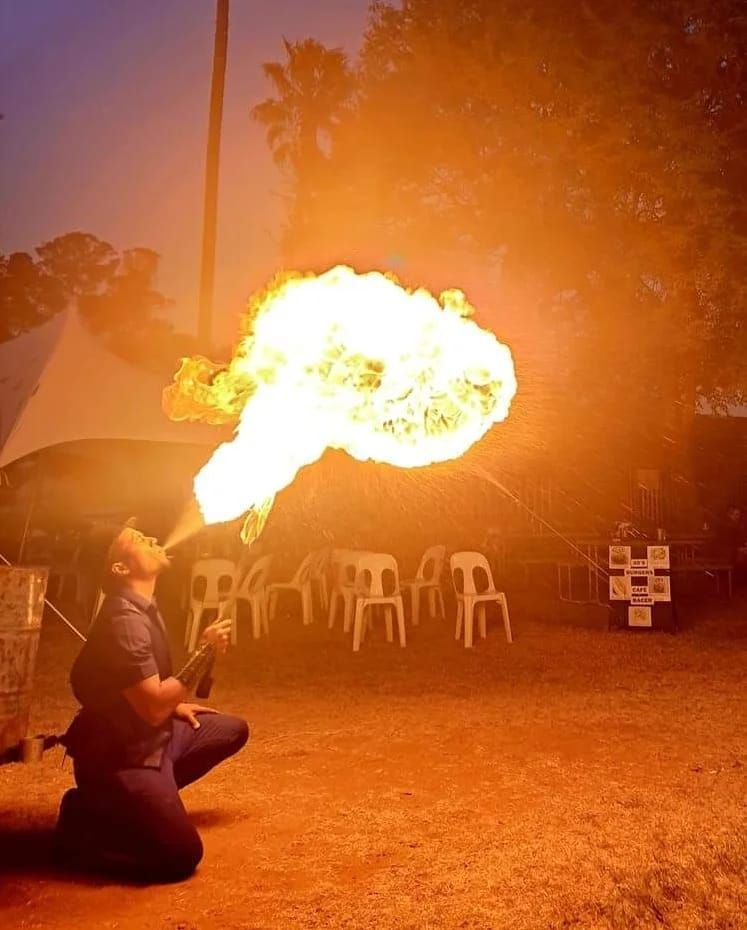A man is blowing flames out of his mouth