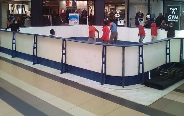 A group of children are playing on an ice rink in a mall