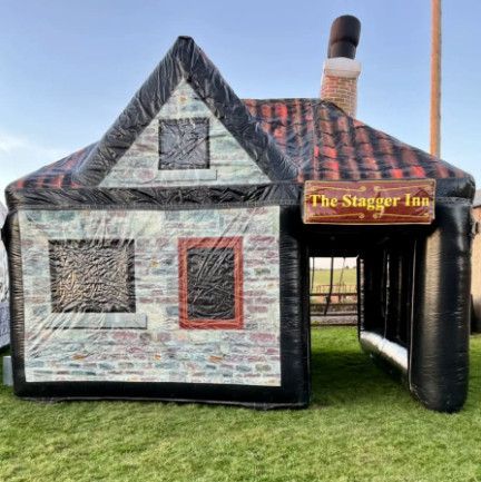 A large inflatable house is sitting on top of a lush green field.