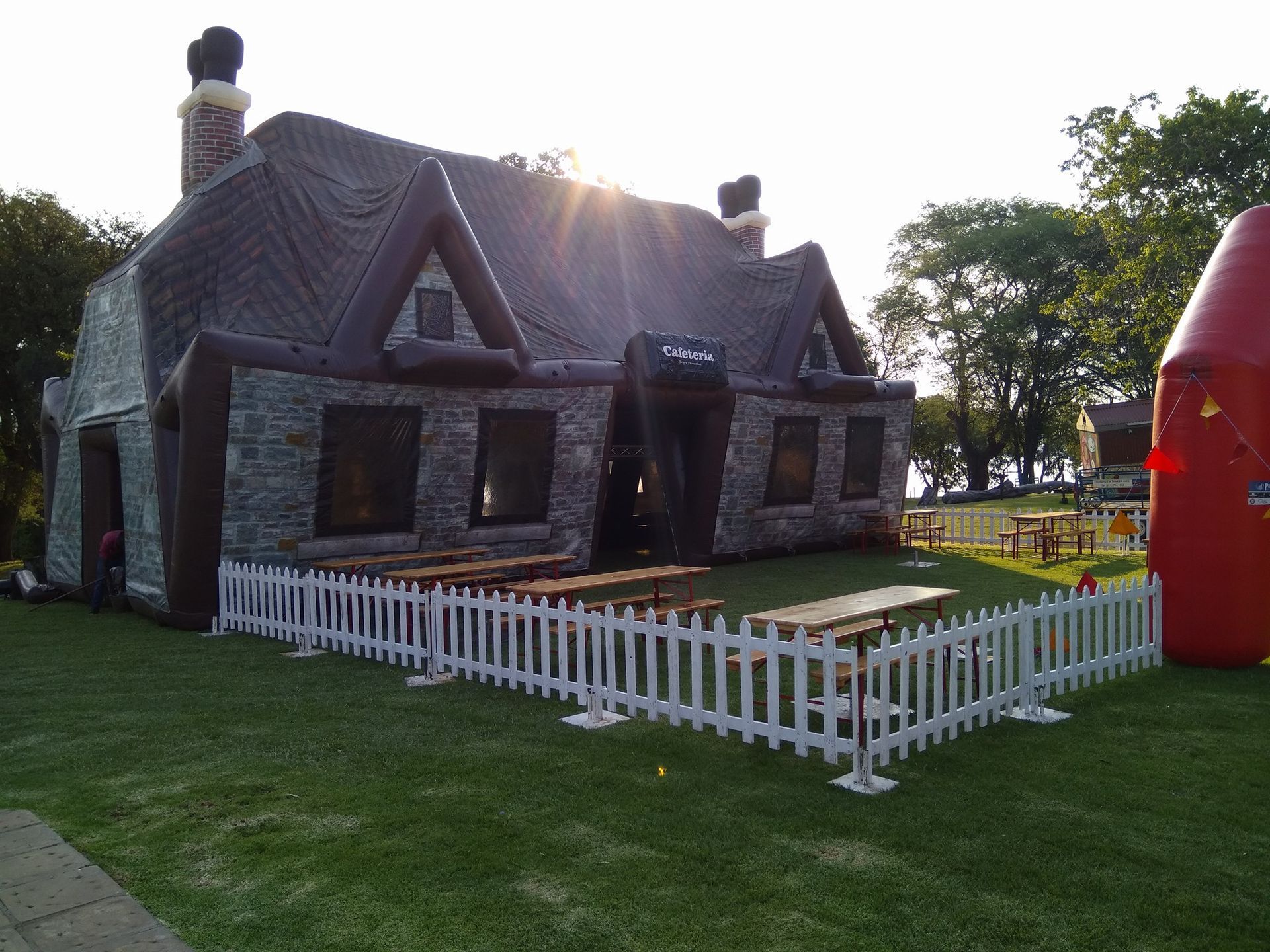An inflatable house with a white picket fence around it