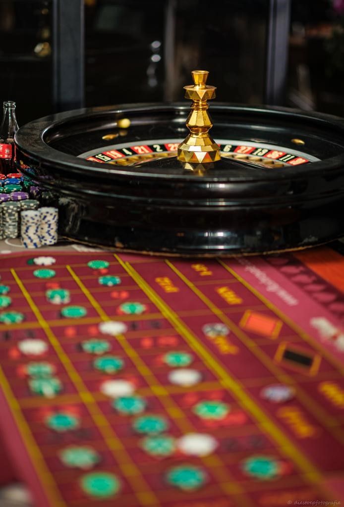A roulette wheel is sitting on top of a roulette table in a casino.