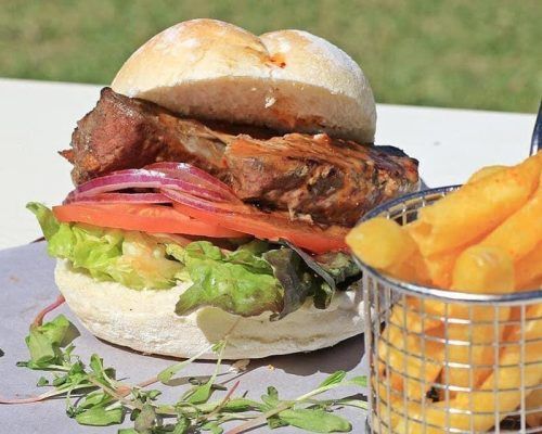 A hamburger and a basket of french fries on a table