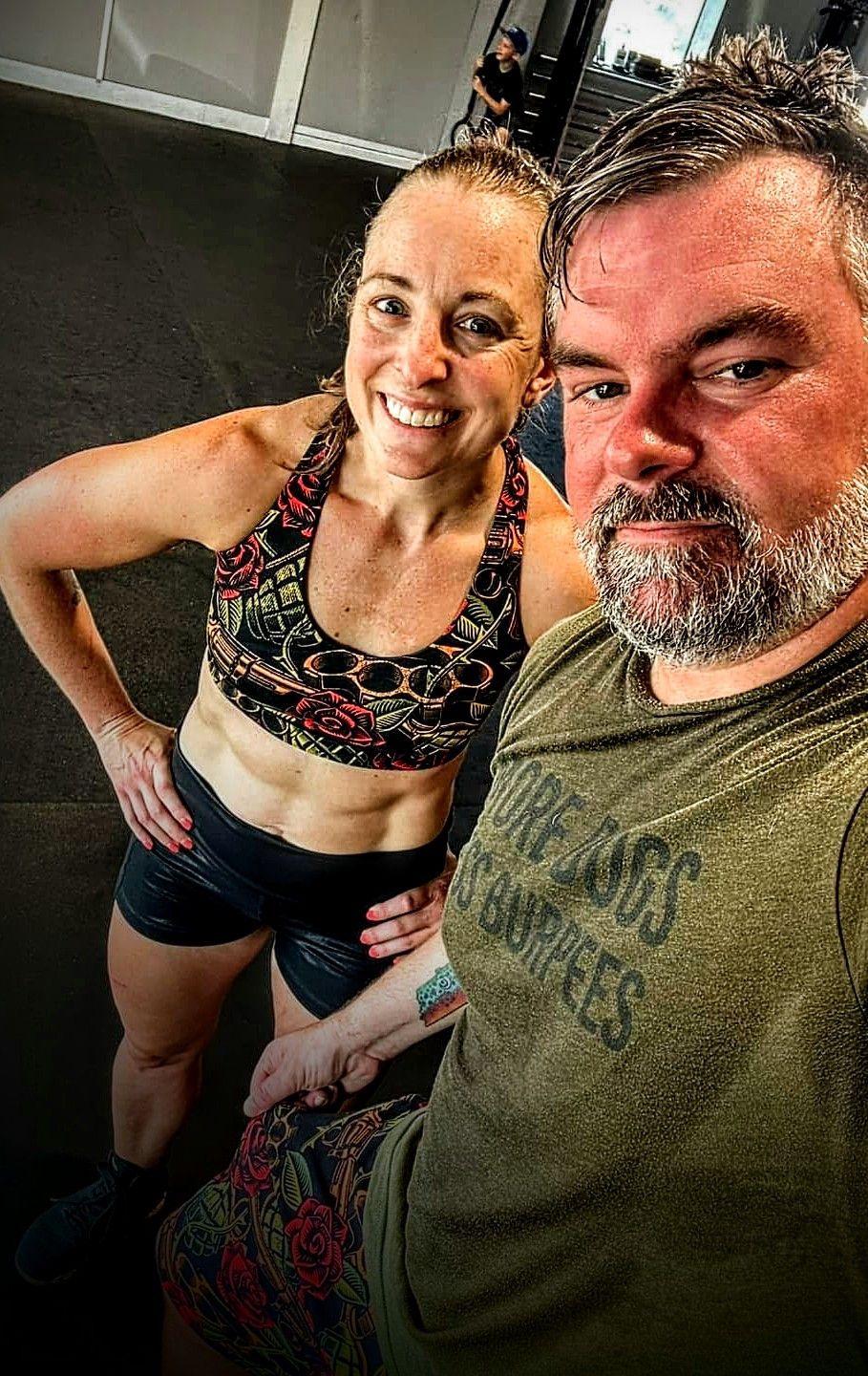 A man and a woman are posing for a picture in a gym.