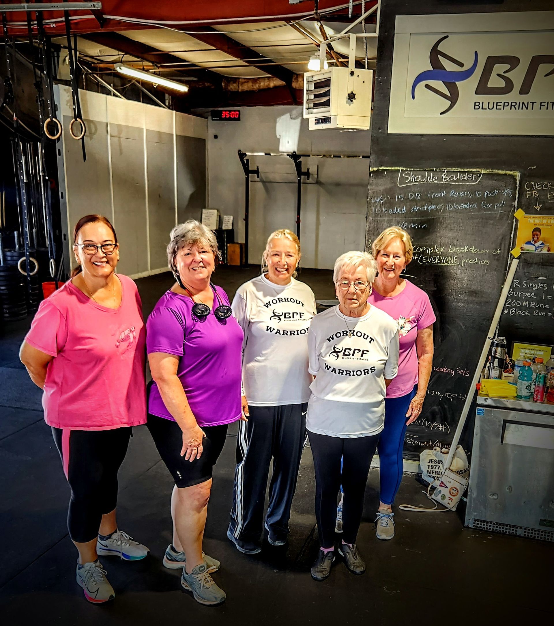 A group of women are posing for a picture in a gym.