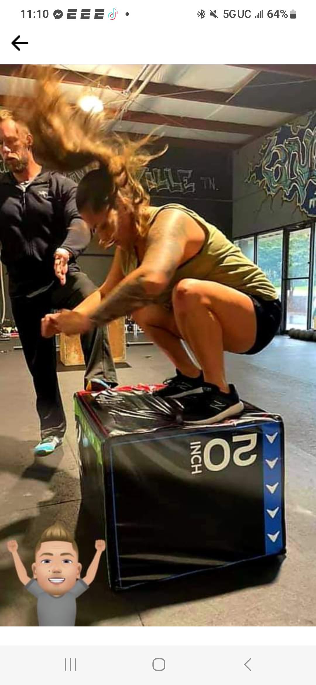 A woman is squatting on a box in a gym.