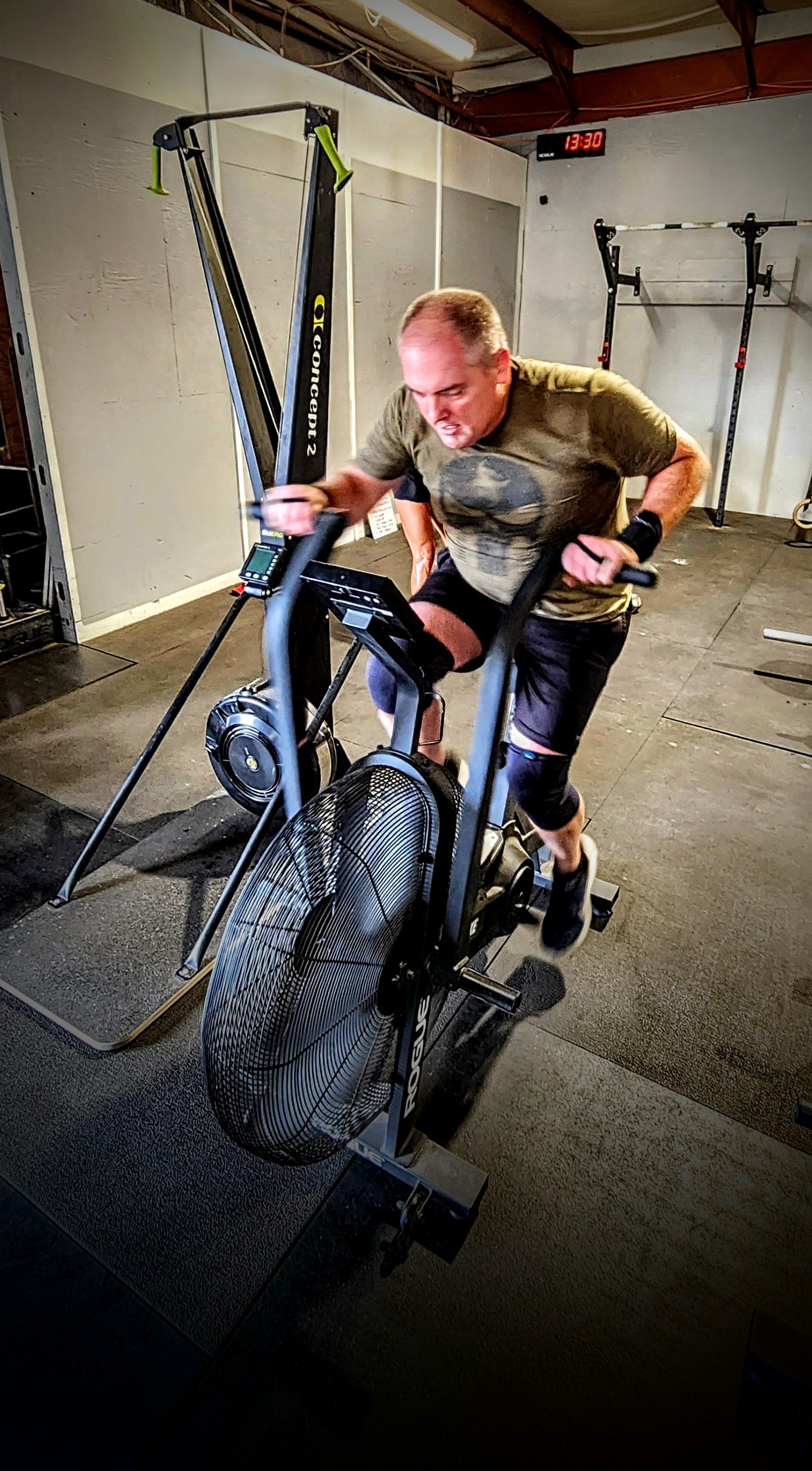 A man is riding an exercise bike in a gym.