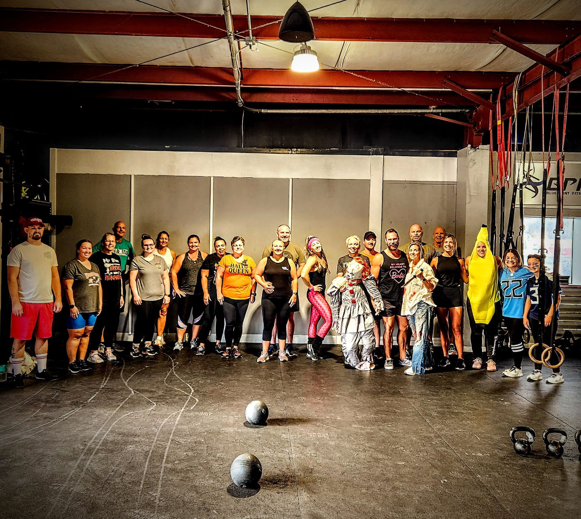 A group of people are posing for a picture in a gym