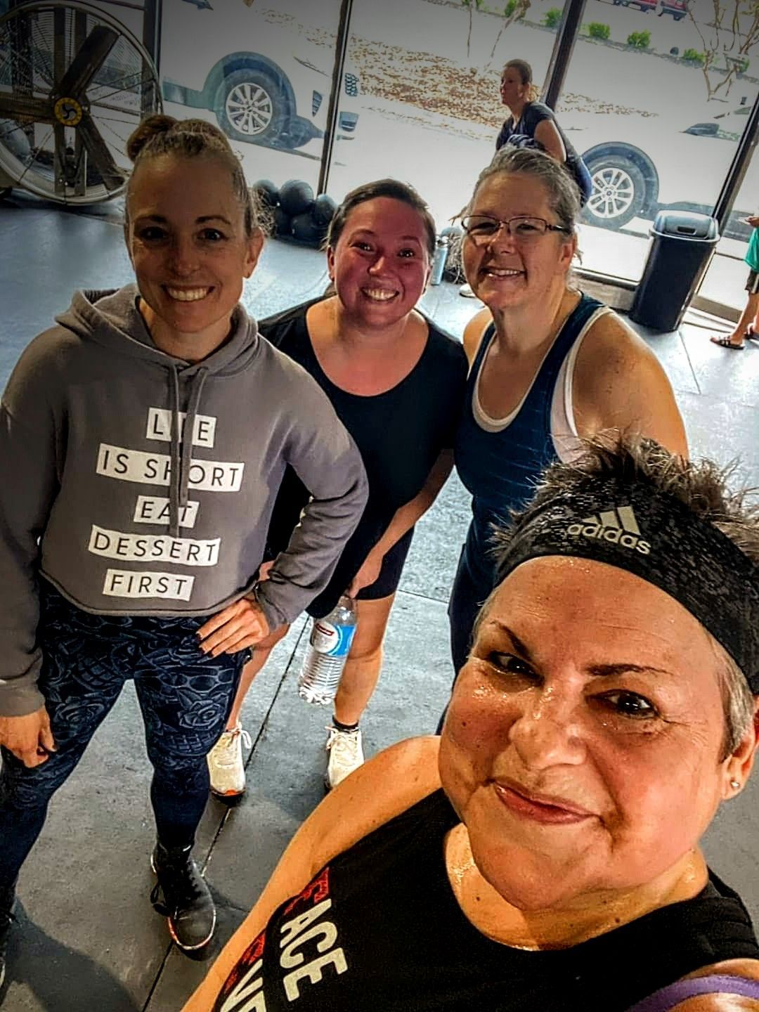 A group of women are posing for a picture in a gym.