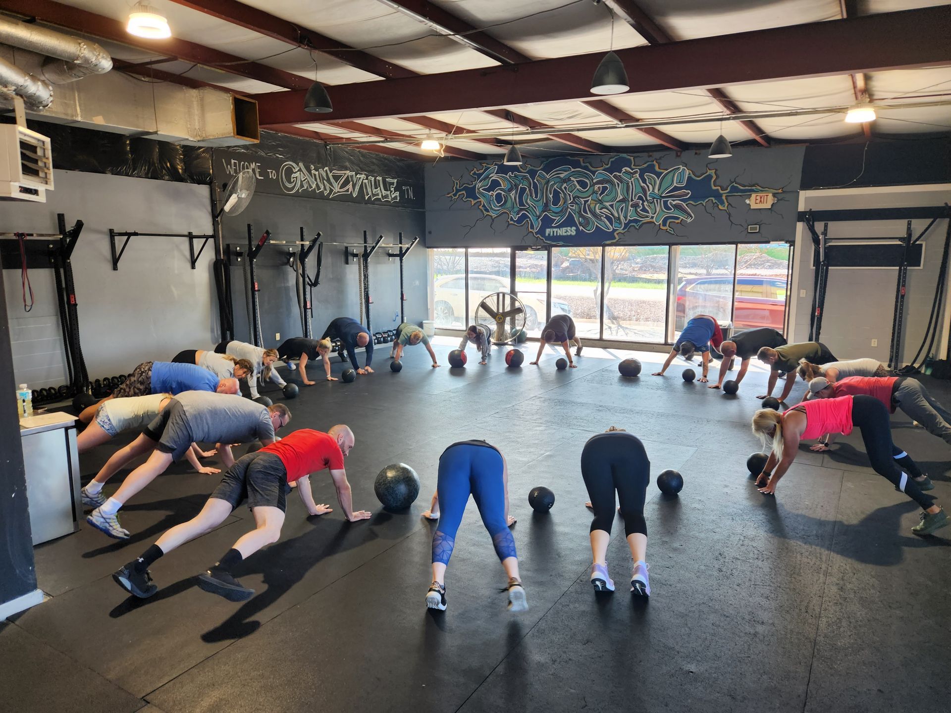 A group of people are doing push ups in a gym.