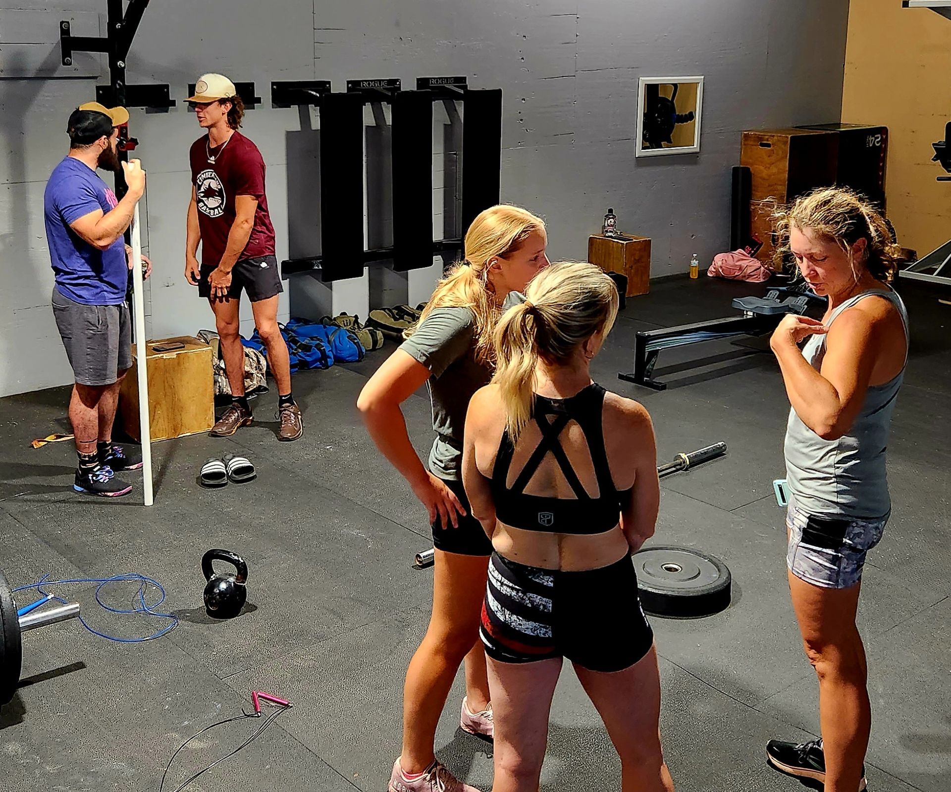 A group of people are standing in a gym talking to each other
