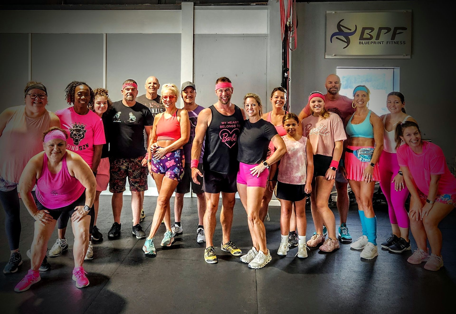 A group of people are posing for a picture in a gym.